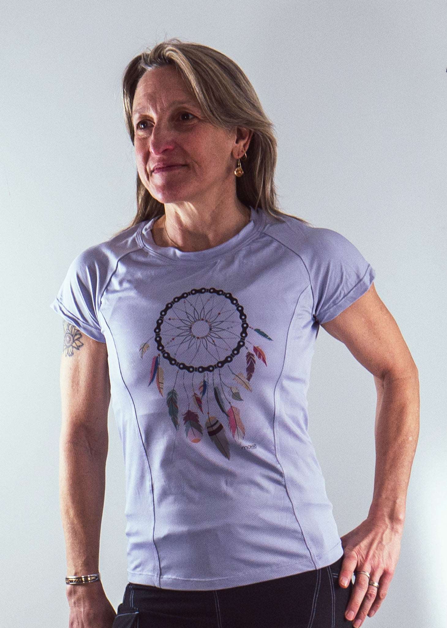 Moxie Tee Jersey in lilac with dreamcatcher design, moisture-wicking fabric, two back pockets.
